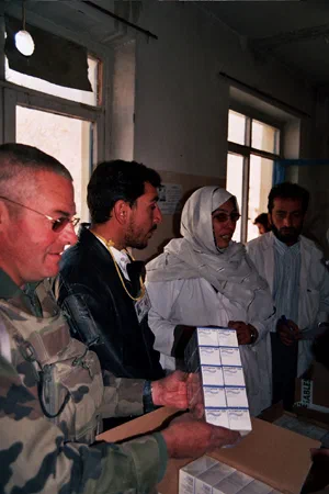 Remise de boîtes de médicaments à l’intérieur d’un bâtiment.