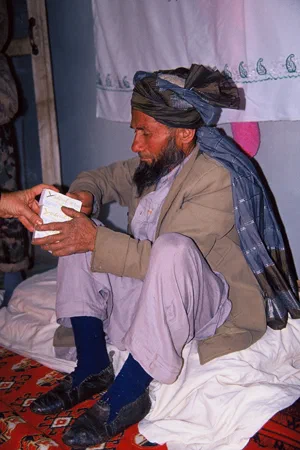 Un homme assis reçoit une boîte de médicaments pendant la mission.