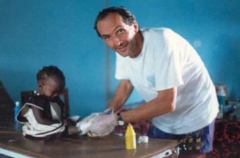 Un bénévole s’occupe d’un enfant assis à une table.