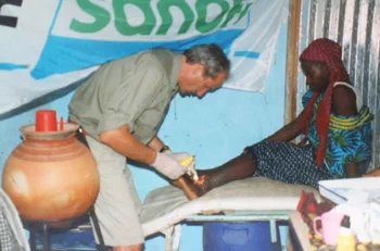 Un bénévole échange avec une femme assise pendant la mission.