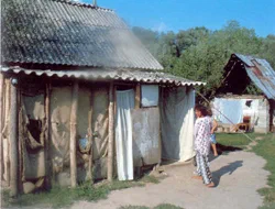 Une personne près d’une maison en bois dans un village.