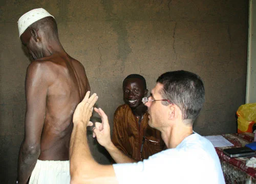 Un bénévole échange avec un homme dans une pièce, pendant la mission au Sénégal.