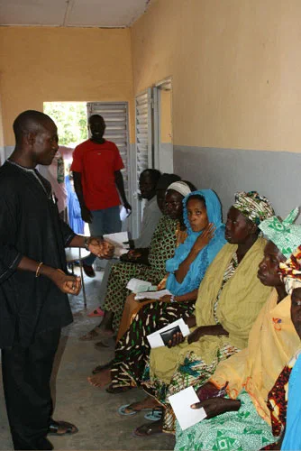 Des femmes et des enfants attendent à l’intérieur d’un bâtiment au Sénégal.