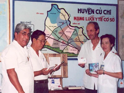 Des membres de l’équipe réunis devant une carte murale au Vietnam.