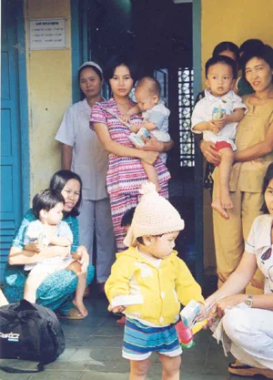 Des femmes et des enfants réunis à l’intérieur d’un bâtiment au Vietnam.
